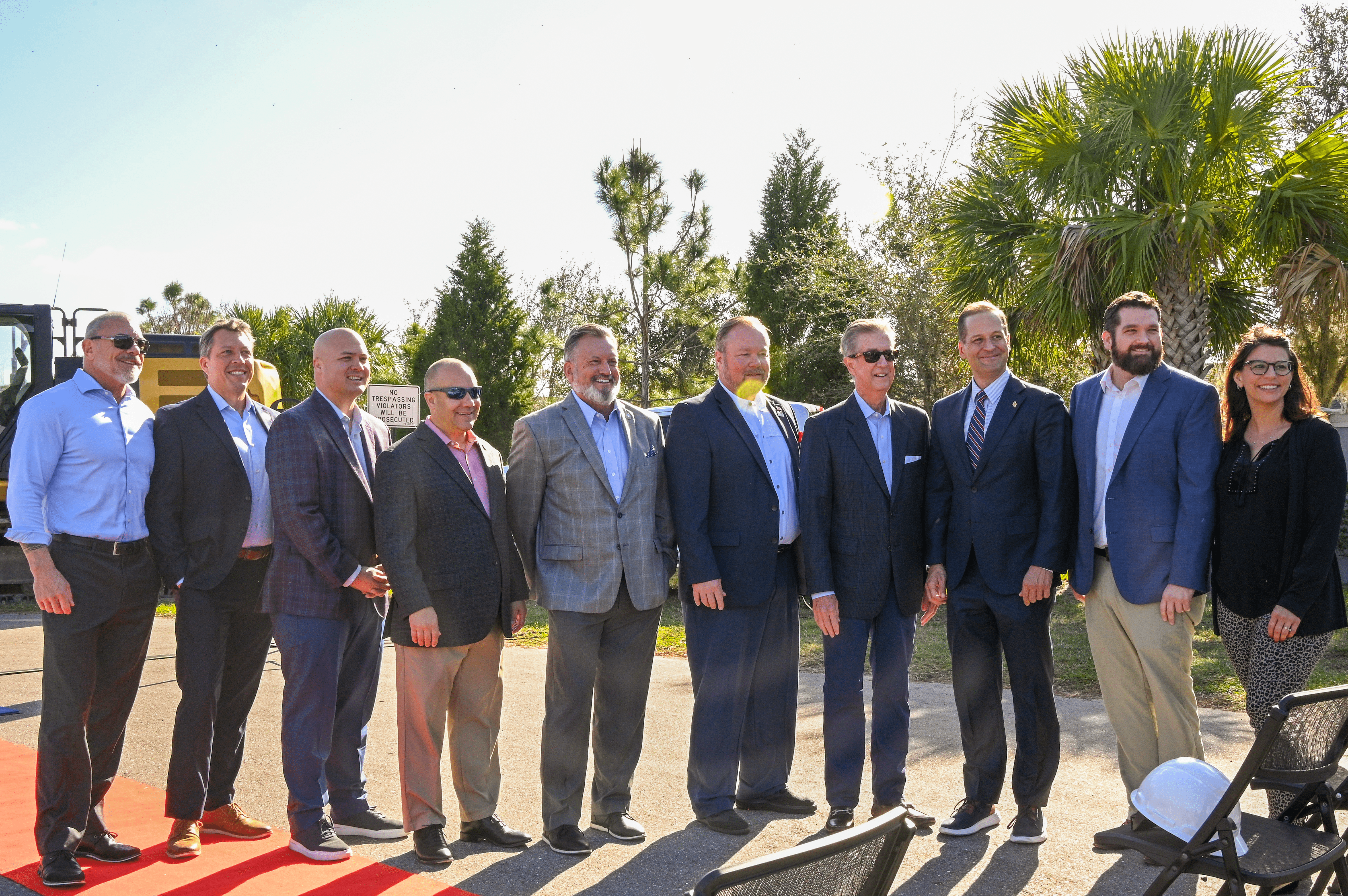 A group photo of 10 people in front of the groundbreaking