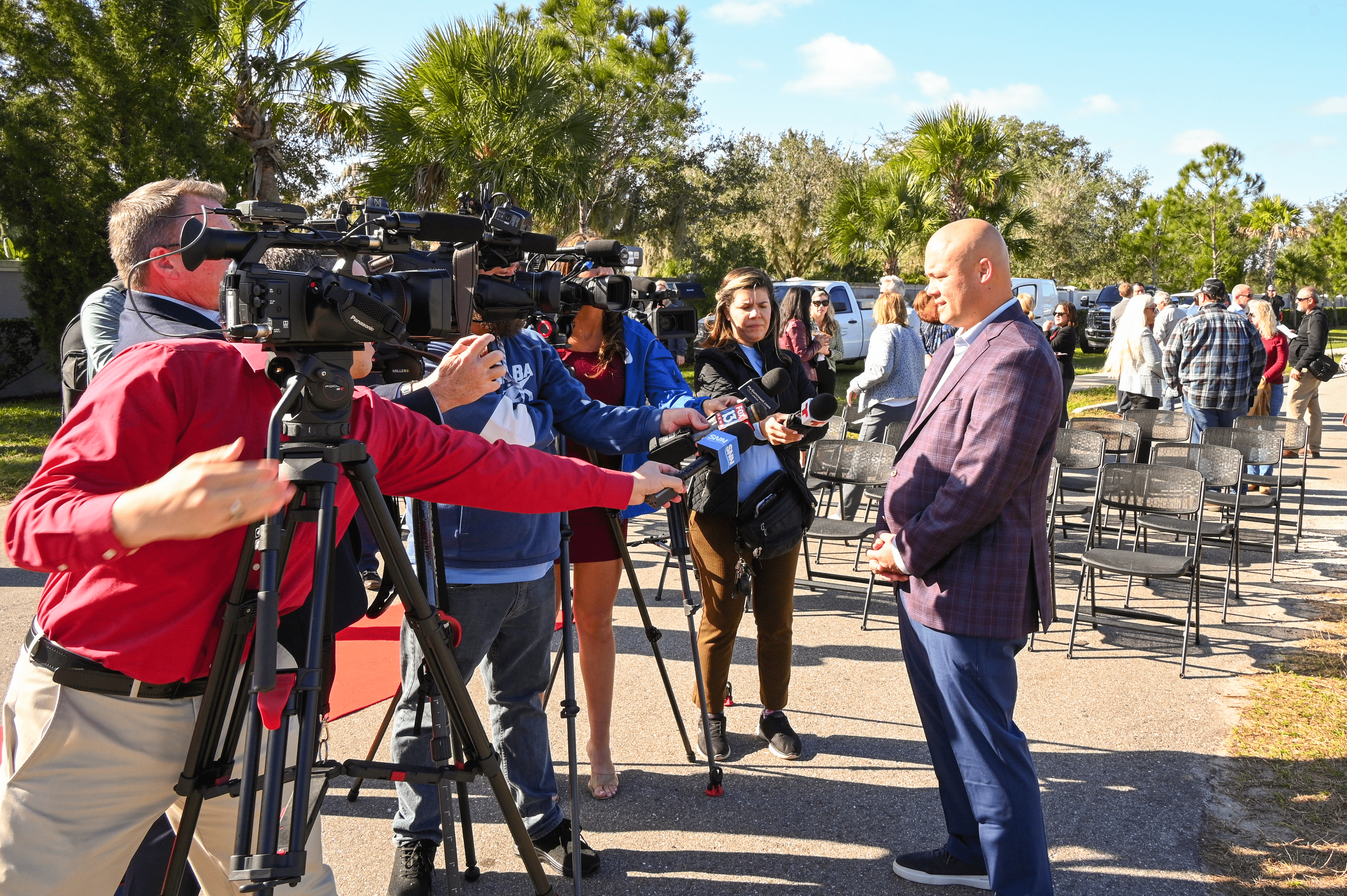 Chairs set up at the groundbreaking event with a TV crew conducting interviews