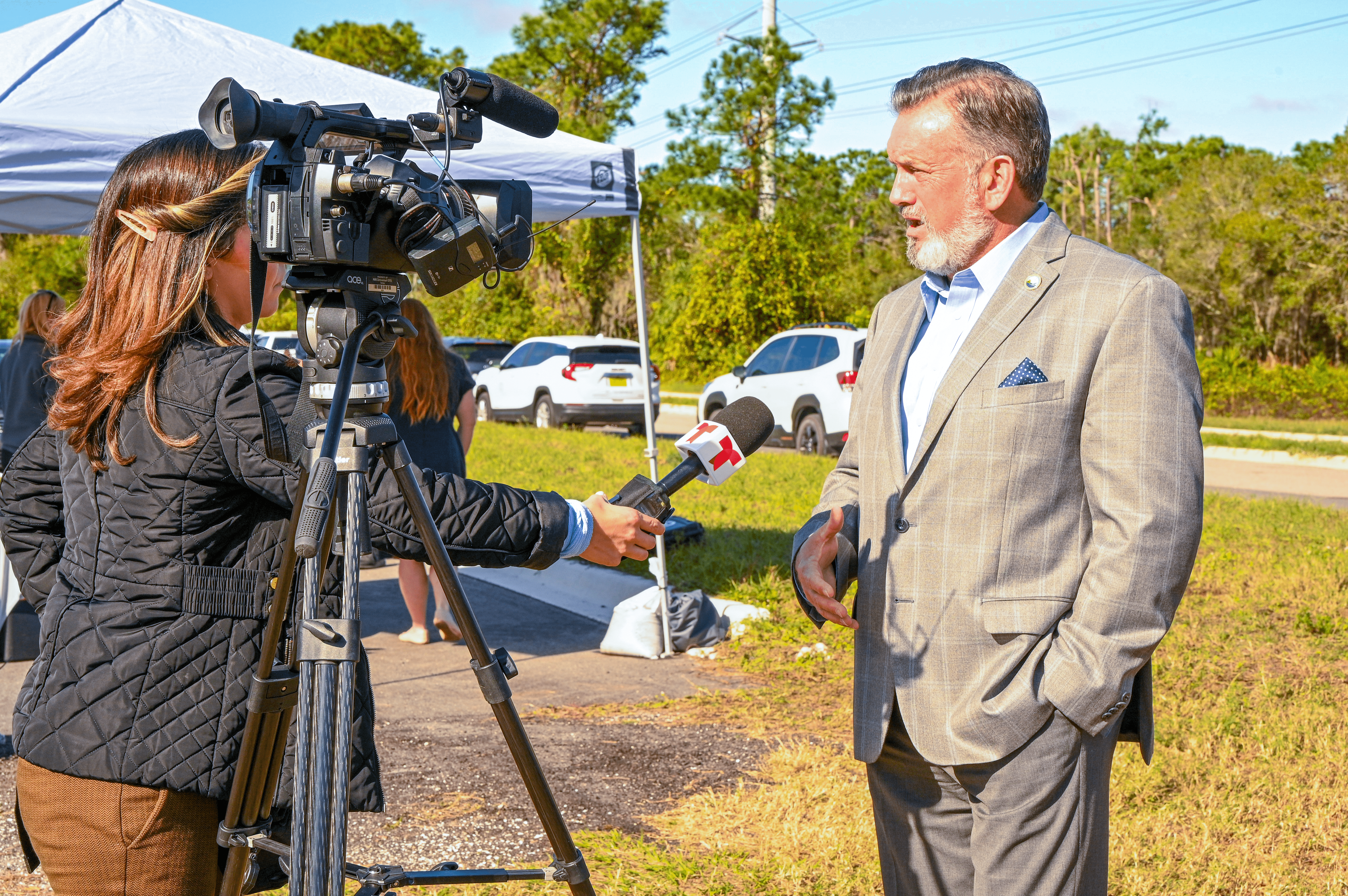 A TV reporter interviewing a man about the groundbreaking